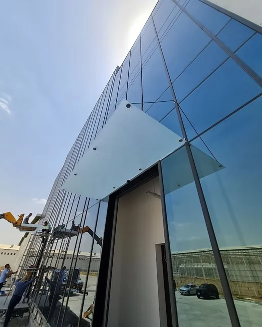 Workers installing an aluminum-framed glass facade